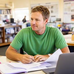 Antenia Arps, regional affairs columnist, seated at a desk with notes in a bright Dubbo newsroom